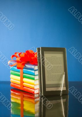 Stack of books with electronic book reader