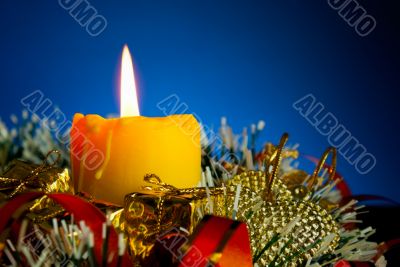 Burning candle with Christmas decorations