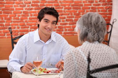 young man having lunch with his grandmother