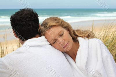 Couple in bathrobe at the beach