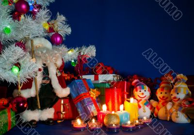 Three snowmen in front of the Christmas presents and burning can