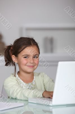 Little girl sat with laptop computer