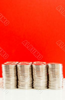 Coins stacked in bars against red background