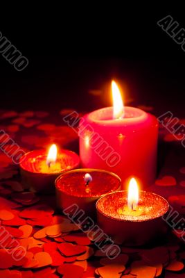 Four burning candles over red background