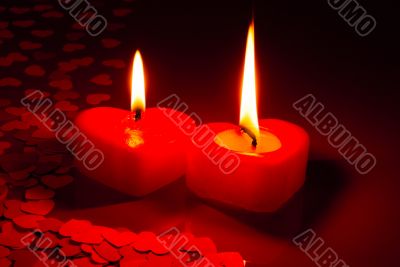 Two burning heart shaped candles