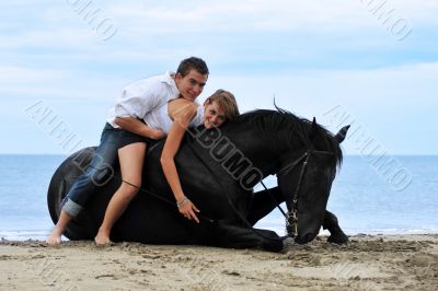 couple and  horse on the beach