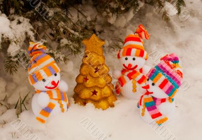 Three snowmen with golden evergreen tree