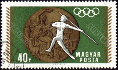 Javelin throwin and Olympic medal on post stamp