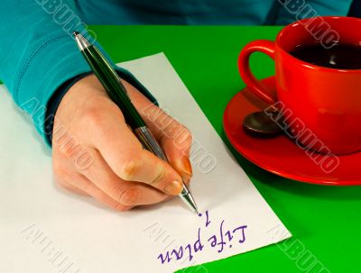 Female`s hand writing a life plan