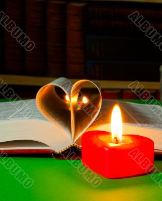 Open book with burning candle