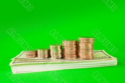 Coins stacked in bars laying on stack of 100 dollar bills