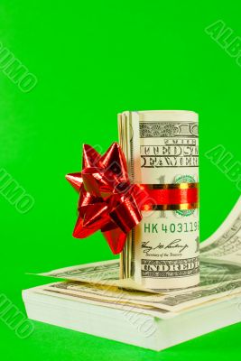 Roll of US dollars tied up with ribbon on the stack of bills