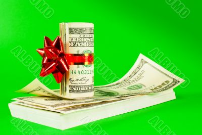 Roll of US dollars tied up with ribbon on the stack of bills