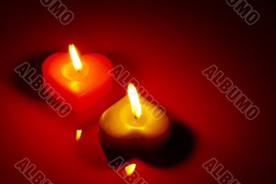 Two burning heart shaped candle