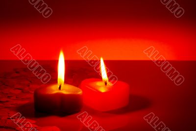 Two burning heart shaped candles