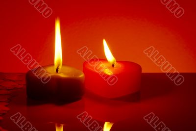 Two burning heart shaped candles