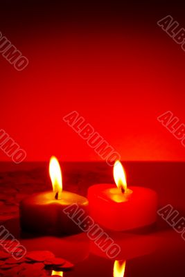 Two burning heart shaped candles