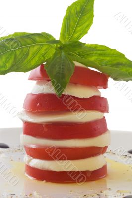 Tower of mozzarella and tomato salad with basil leaf, isolated o