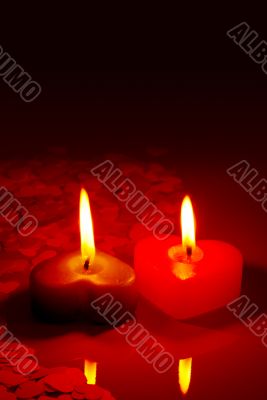 Two burning heart shaped candles