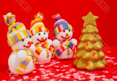 Three snowmen with golden evergreen tree