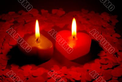 Two burning heart shaped candles