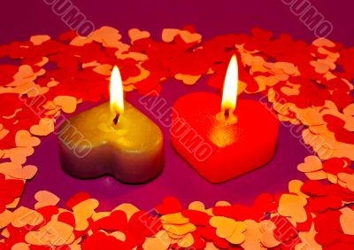 Two burning heart shaped candles