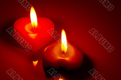 Two burning heart shaped candles