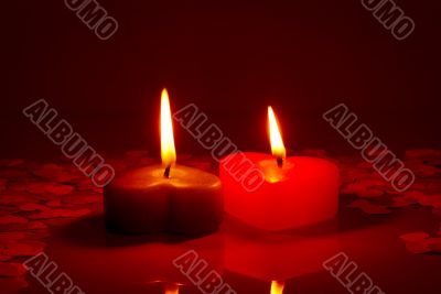Two burning heart shaped candles