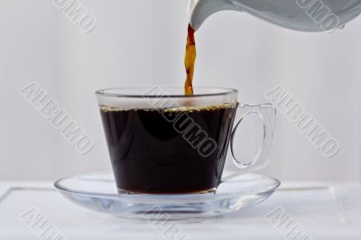 Pouring coffee into an almost full cup