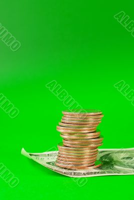 Coins stacked in bars laying on 100 dollar bill