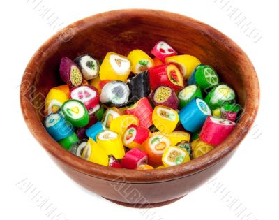 Varicoloured lollipop in brown wooden plate