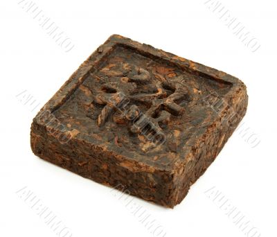 Pressed briquette of green tea with hieroglyphic on white backgr