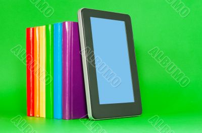 Row of colorful books and tablet PC