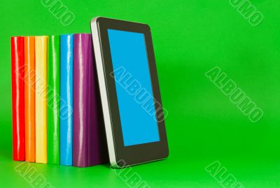 Row of colorful books and tablet PC