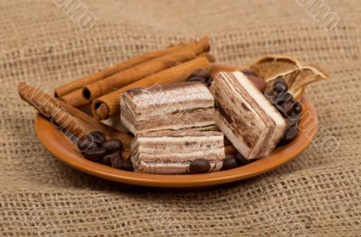 Sweets, cinnamon, nuts and coffee beans on a saucer.