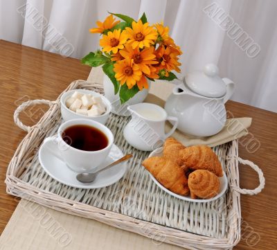 croissants with tea and milk on a tray