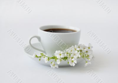 A cup of black coffee with flowers