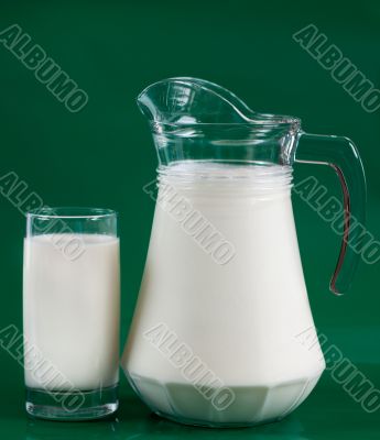 A pitcher of milk and a glass