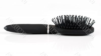 Black hairbrush massage on a light background