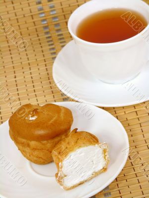 Brewing delicious cake with cream and a cup of tea 
