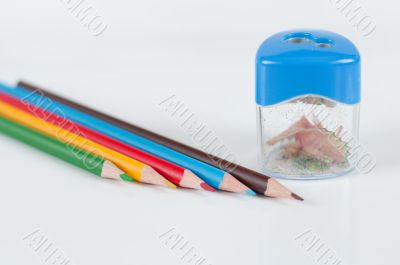 Colored pencils and sharpener on a gray background
