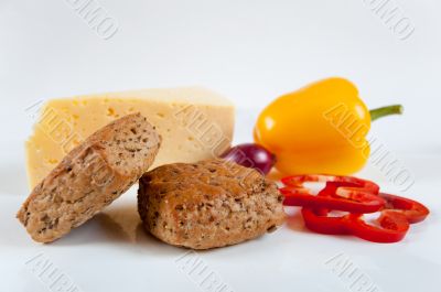 The concept of healthy food - bread with bran, vegetables and cheese on a light background