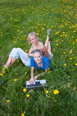 Two female students with a laptop in the park