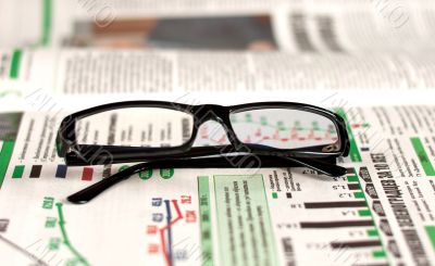 Eyeglasses lying around newspapers