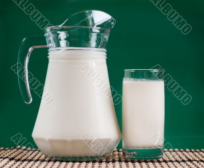 A pitcher of milk and a glass