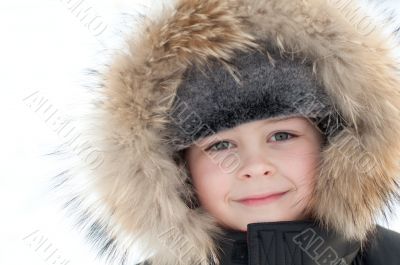 Portrait of a boy in a jacket with fur