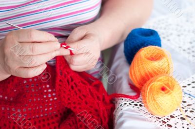 Women`s hands are knitted shawl