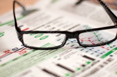 Eyeglasses lying around newspapers