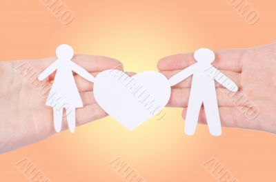 Paper family in hand with a big hearth isolated on white
