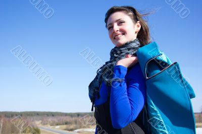 A woman holds a coat over his shoulder and smiles